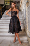 Woman wearing strapless black dress with embroidered flower detailing