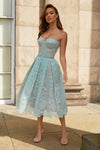 Woman wearing mint green strapless dress with lace detailing