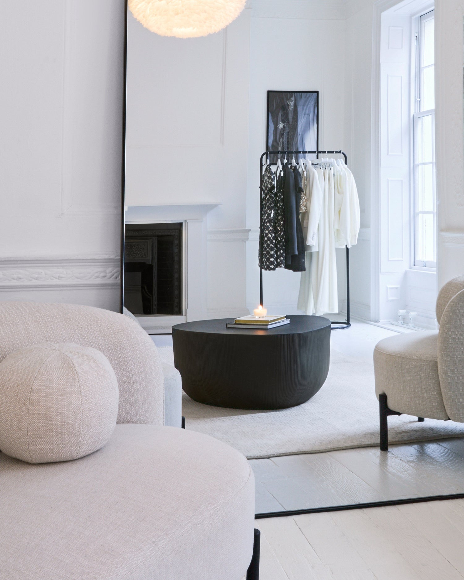 Modern living room with white walls, a black coffee table, and a fireplace.