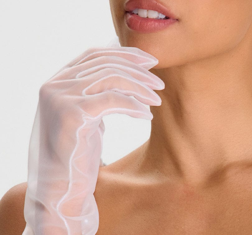 Close-up of a woman's hand wearing a clear glove against a neutral background