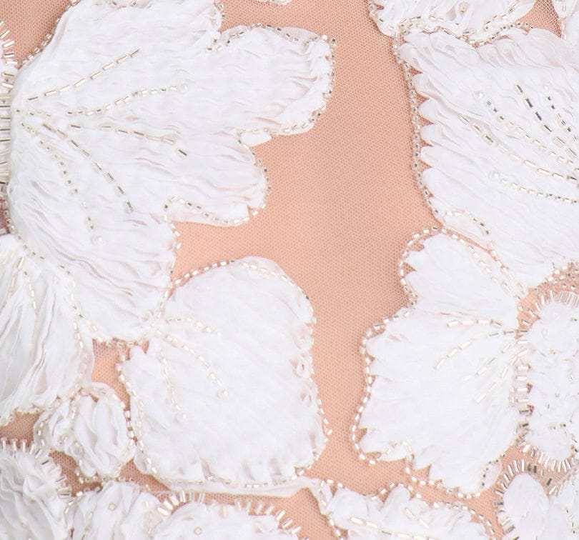 Close-up of a white lace fabric with a pink background