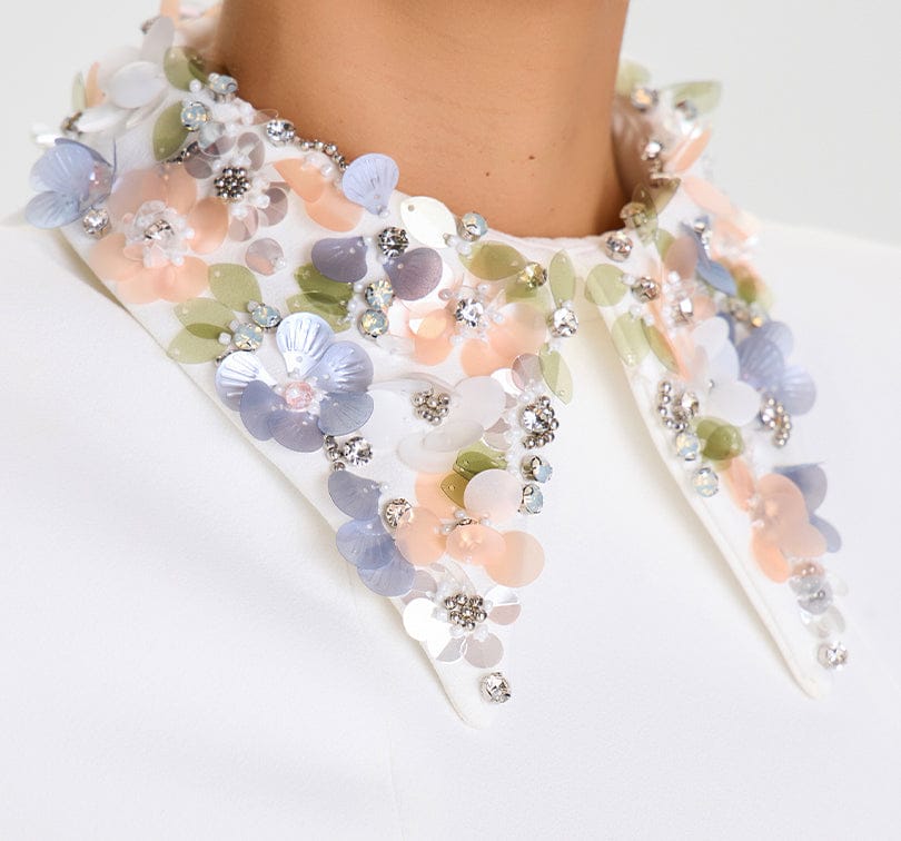 Decorative collar with floral and bead embellishments on a white background