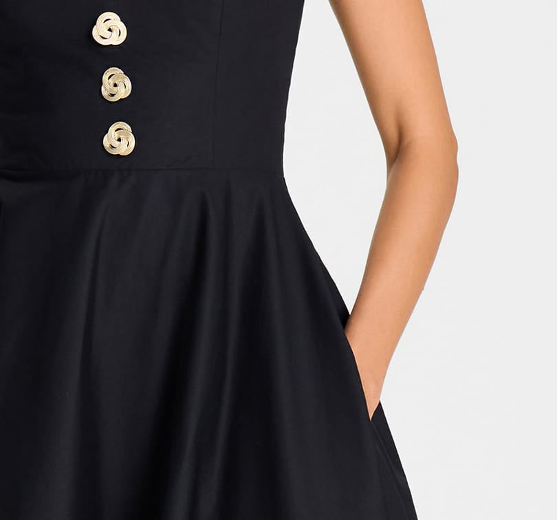 Black dress with gold buttons on a white background