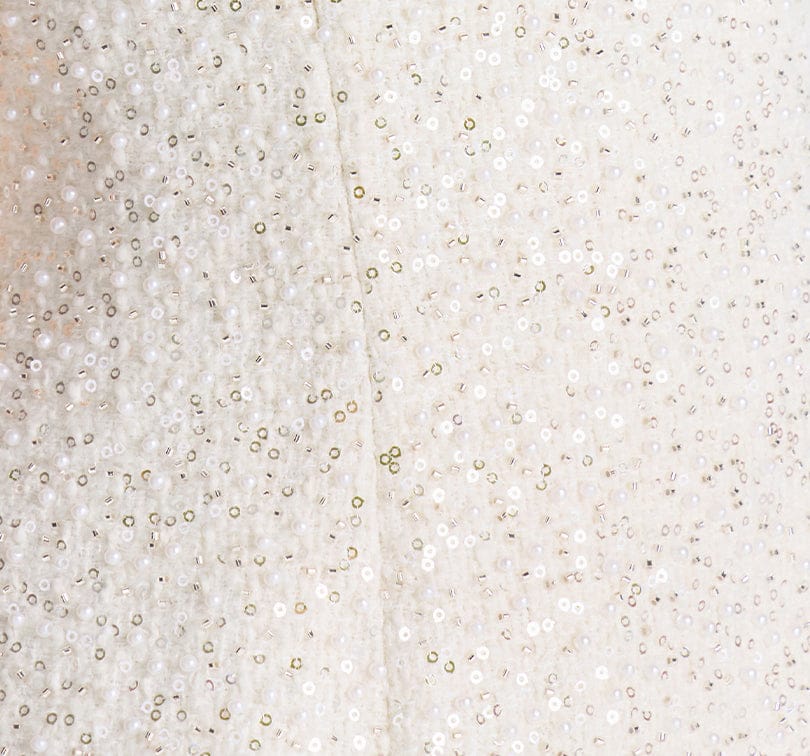 Close-up of a textured white surface with small beads or particles.