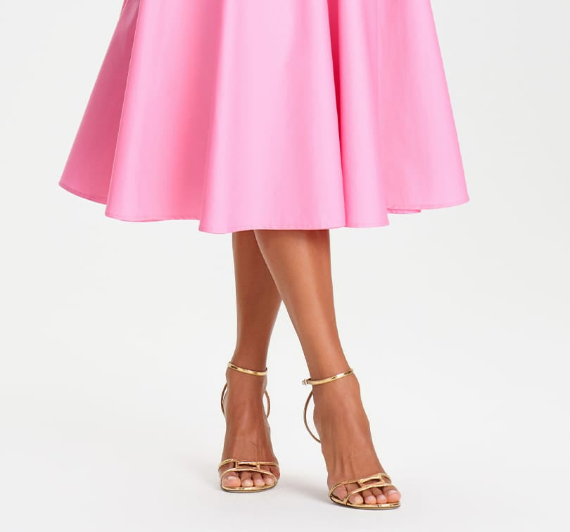 Pink skirt and gold sandals on a white background