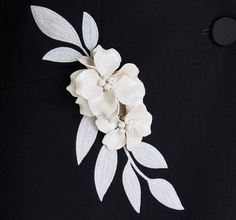 White floral and leaf design on a black background