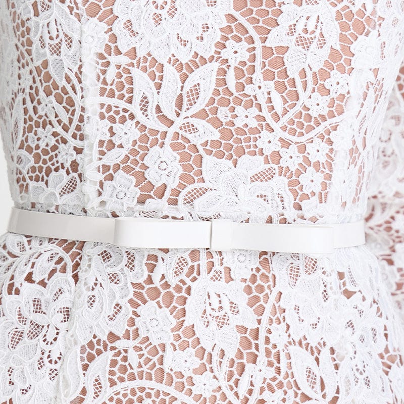 Close-up of a white lace dress with a belt