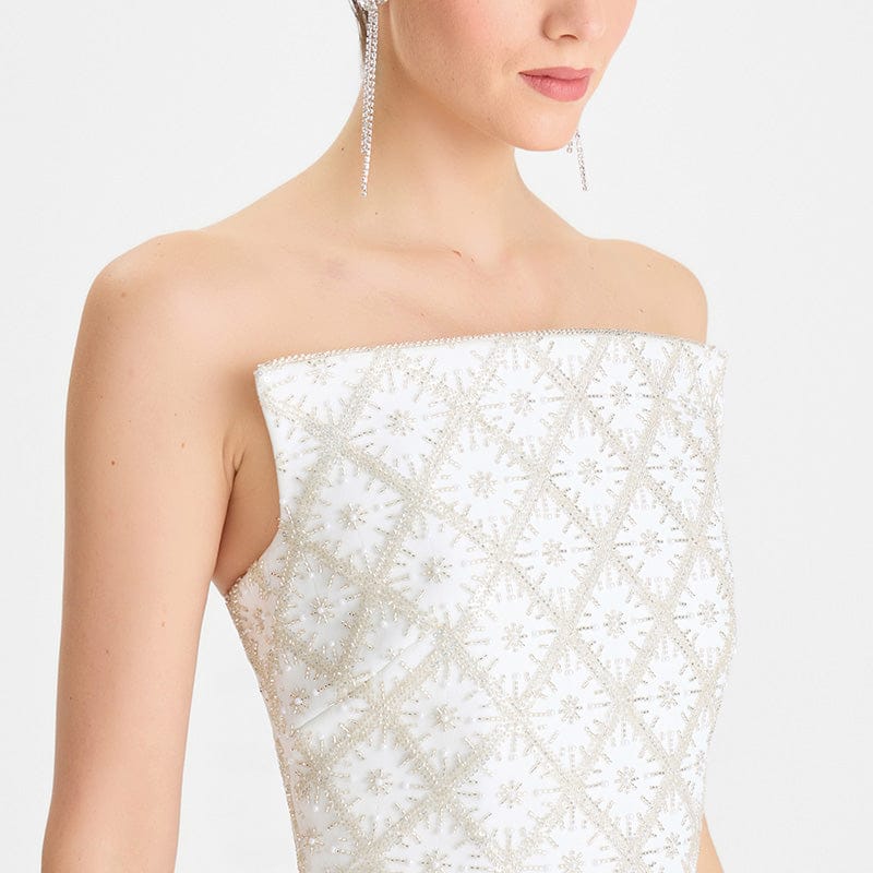 White strapless dress with intricate beading on a white background