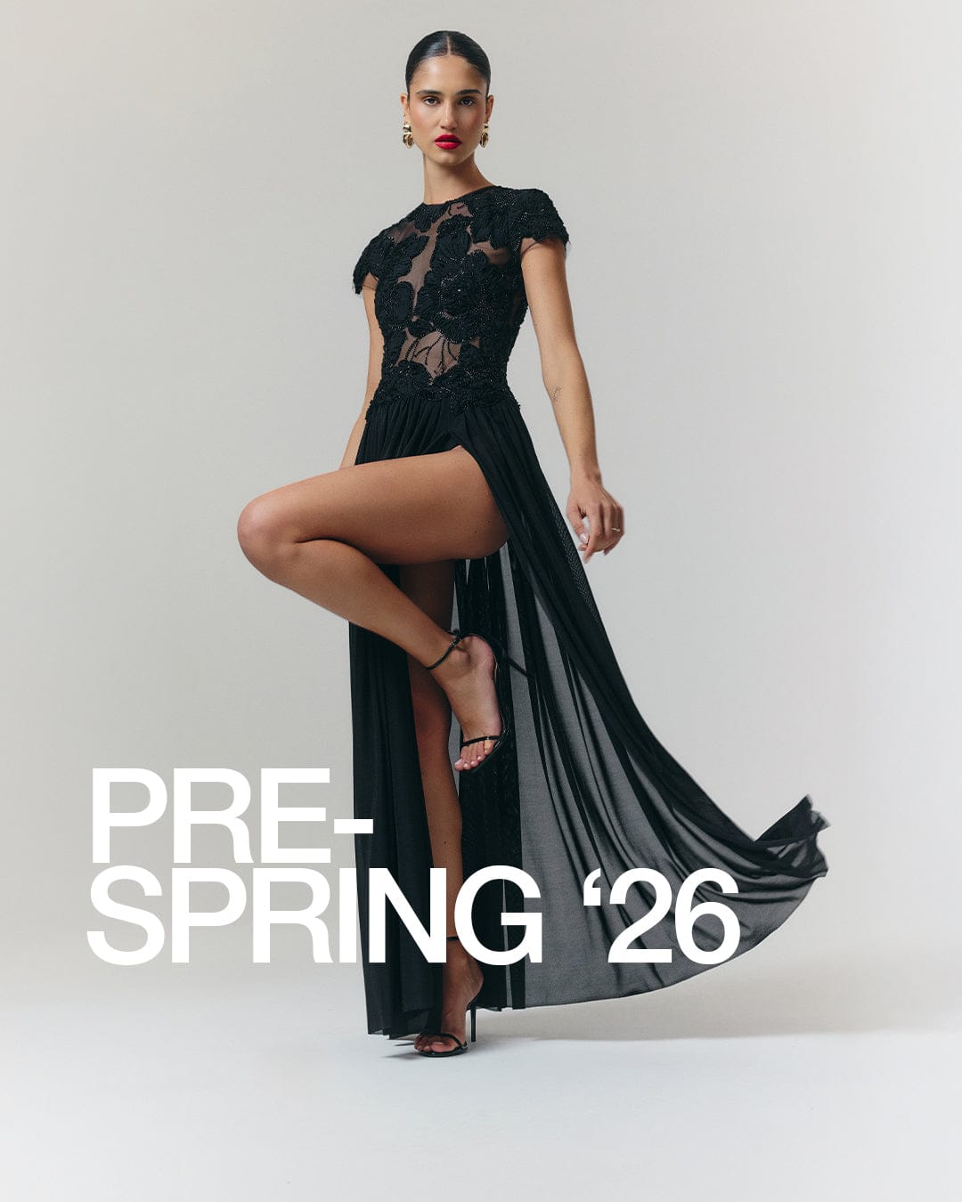 Woman wearing a black lace dress with 'Pre-Spring '26' text on a gray background