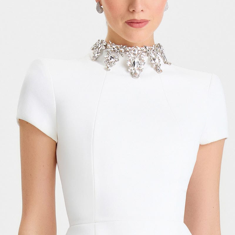 White dress with a decorative collar on a plain background